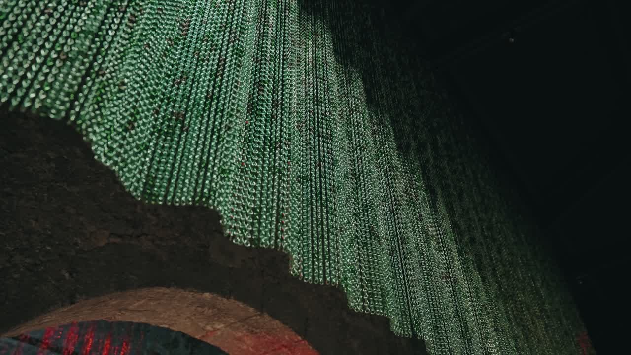 Close view of green bead light strands forming abstract ceiling pattern