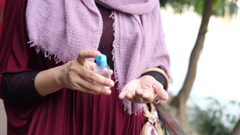 woman applying hand sanitizer