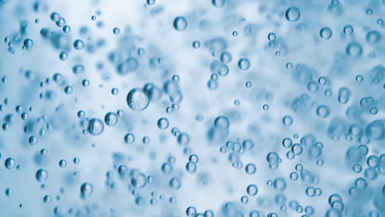 Molte bolle d'acqua in primo piano in acqua blu, onda d'acqua astratta con bolle al rallentatore
