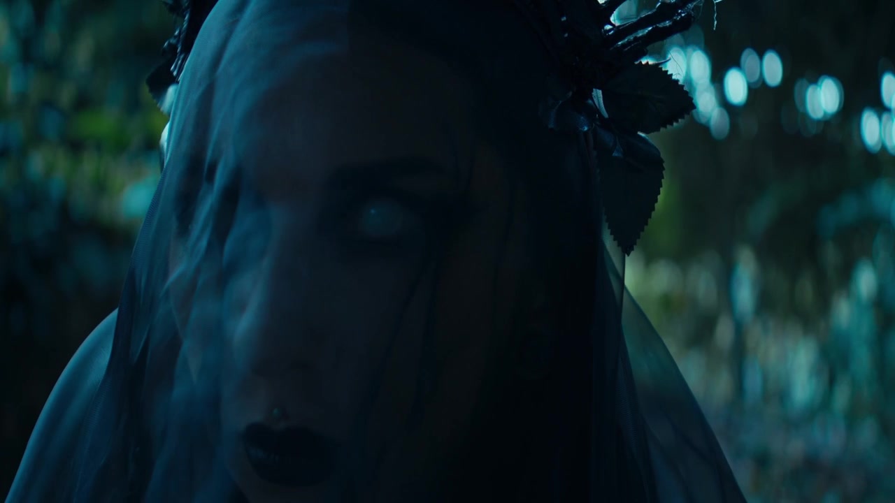 Mulher com véu gótico e coroa em uma floresta escura