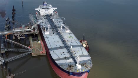 crude oil tanker ship loading at refinery harbour terminal aerial view orbit right