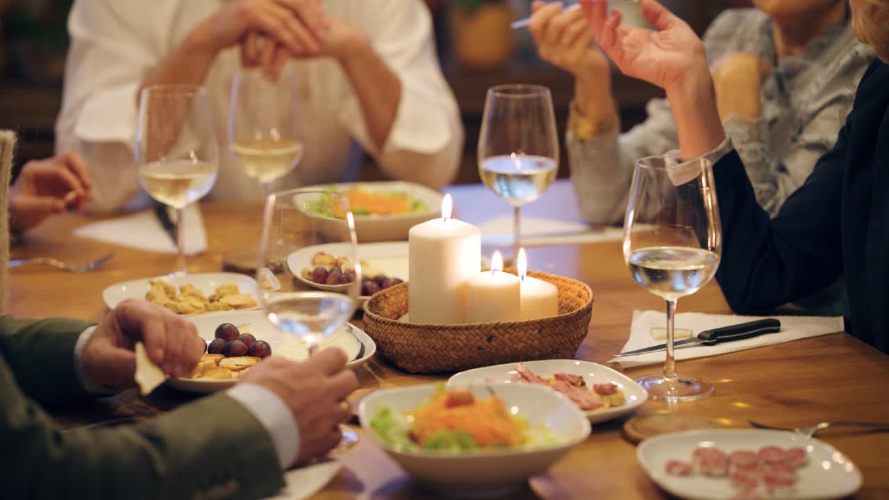 Persone che cenano insieme con cibo e vino a un tavolo accogliente