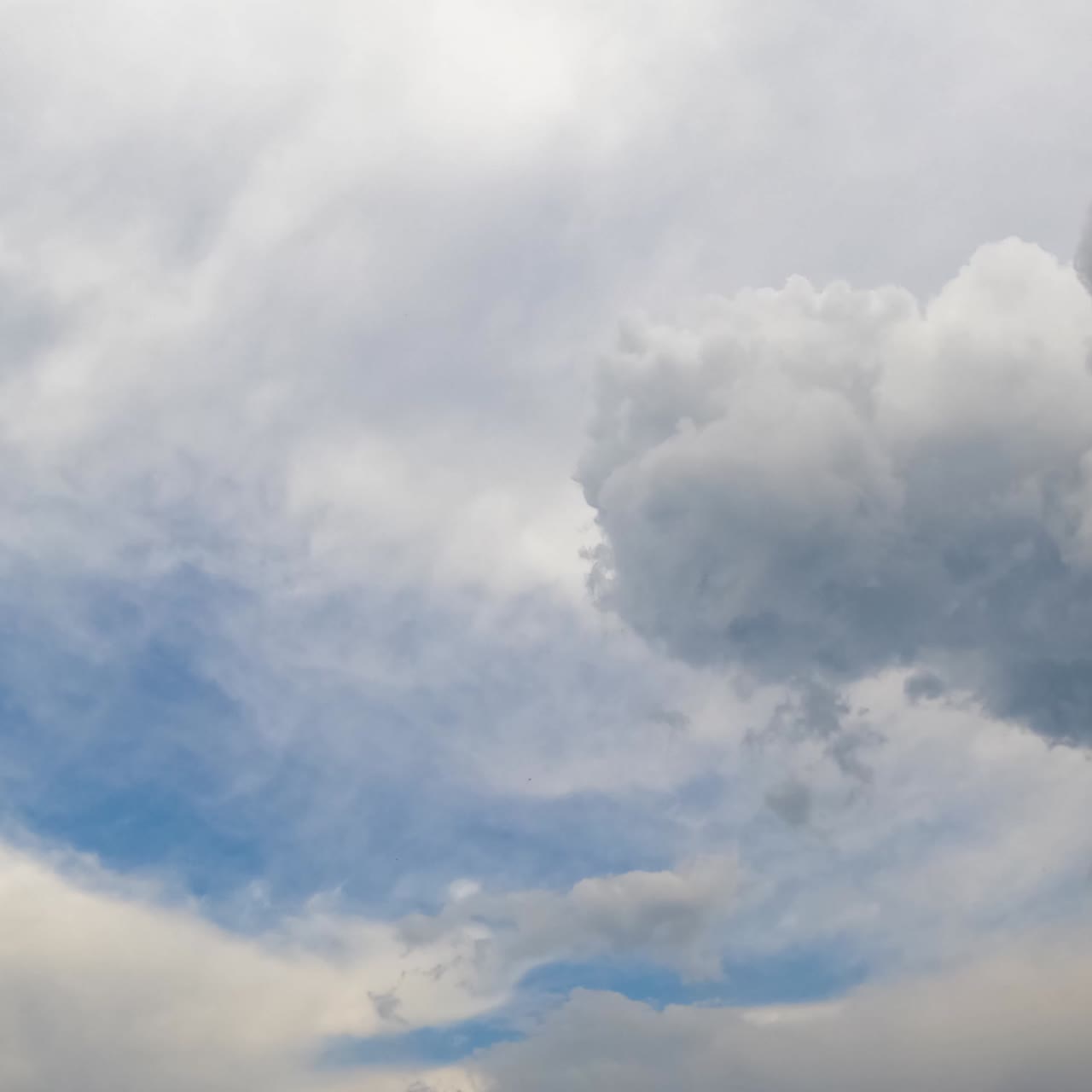 Grey cumulus clouds are disappearing in the wind. Cirrus cloudscape covering the sky. Timelapse