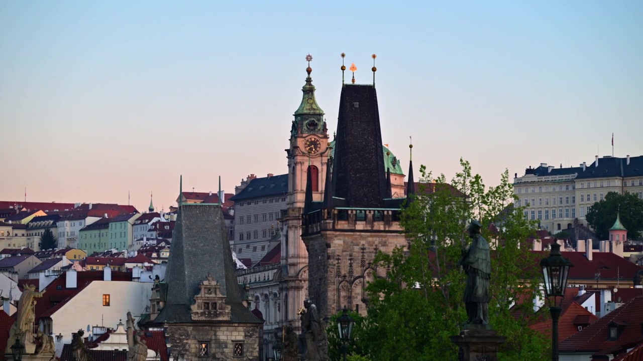 La Torre del Ponte della Città Piccola e il campanile della Chiesa di San Nicola sopra i tetti rossi all'alba, Praga, Repubblica Ceca