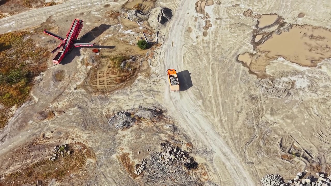 Granite quarry operation with heavy machinery moving along the path