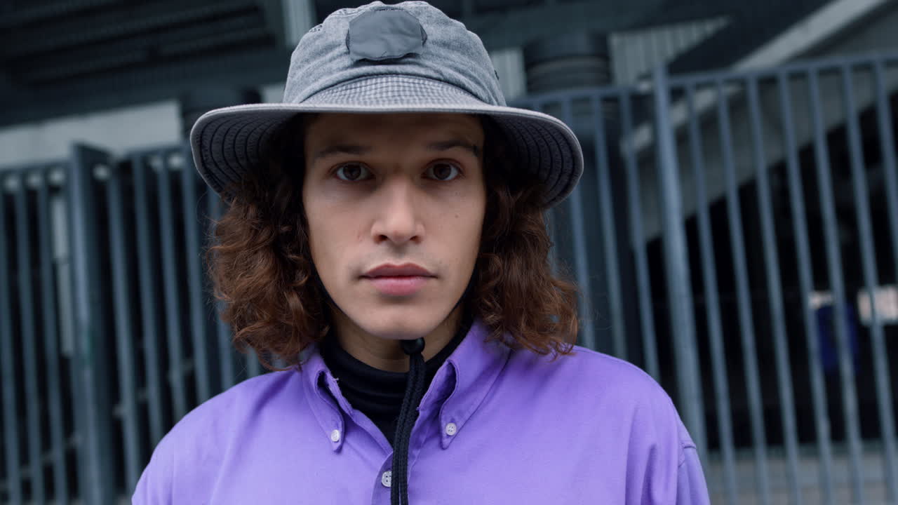 시내에서 포즈를 취하는 집중된 남자, 여름에 거리에서 카메라를 찾는 심각한 남자.