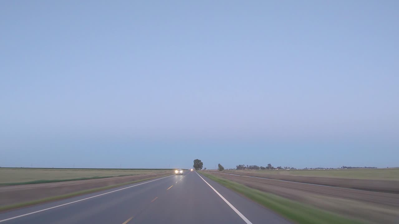 저녁에 시작하여 밤으로 전환하는 시골 도로를 운전하는 하이퍼스