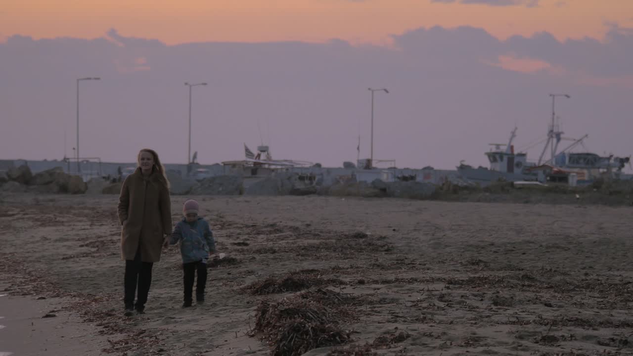 madre e hijo caminando por la orilla en un día frío