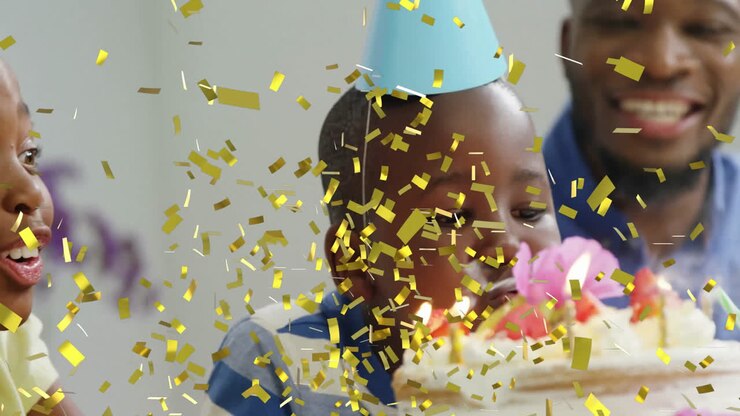 Animation de confettis dorés sur des enfants célébrant un anniversaire avec un gâteau et des bougies