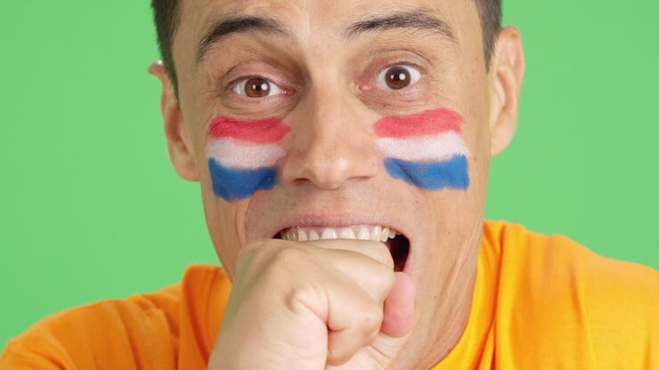Uomo molto nervoso che fa il tifo per la squadra olandese durante una partita difficile