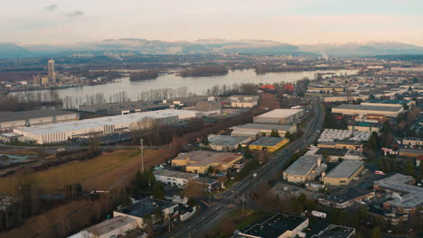 Aerial-flying-over-a-gritty-industrial-area-along-the-Fraser-River-in-Greater-Vancouver,-British-Columbia