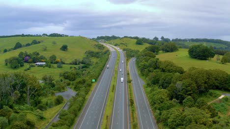 Fahrzeuge,-Die-Auf-Den-Bergauf-Führenden-Fahrbahnen-Fahren,-Umgeben-Von-Grüner-Landschaft-In-Byron-Bay,-Nsw,-Australien