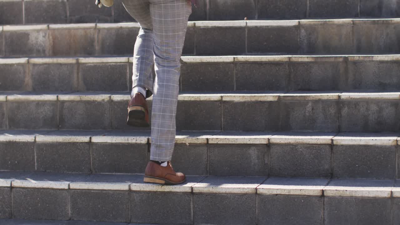 아프리카계 미국인 남자의 다리가 도시에서 위층을  ⁇ 고 있습니다.