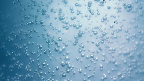 muchas burbujas de agua en agua azul de cerca, onda de agua abstracta con burbujas en cámara lenta.