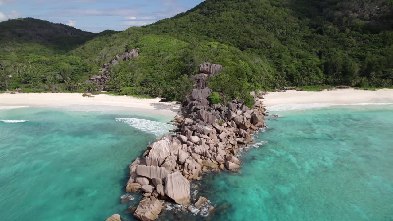 Dronový záběr úžasné přírody z pláží Grand Anse a Petite Anse, žulové kameny podél vody, tříštící se vlny, nedotčená příroda, La Digue, Seychely 30fps 004.