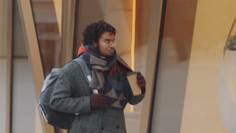 man drinking coffee outdoors in the city