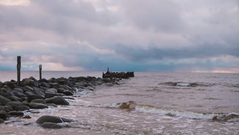 the sea wave washes away the old abandoned stone pier