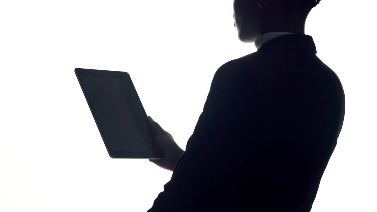 Silhouette di un uomo che tiene una tavoletta