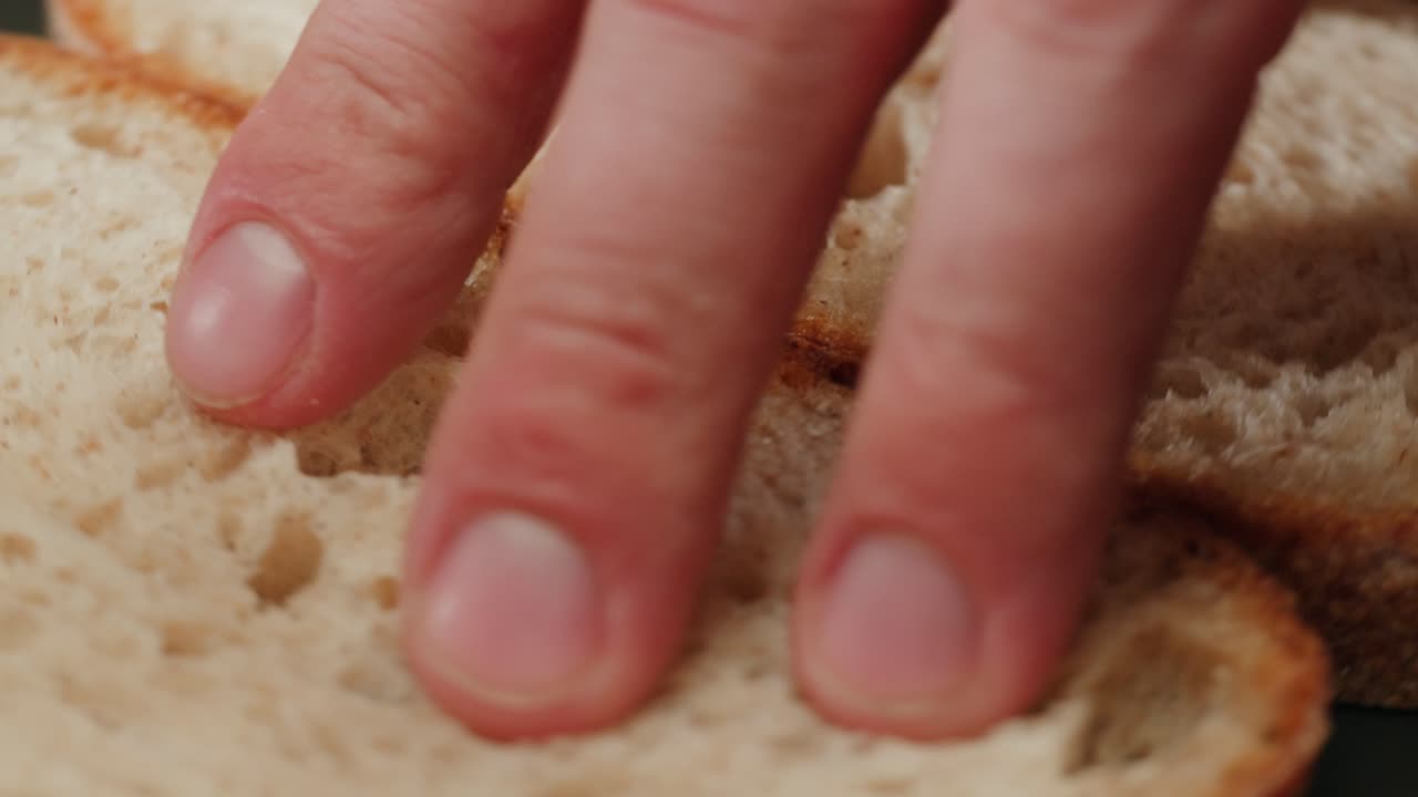 Close-up view of hands touching slices of bread