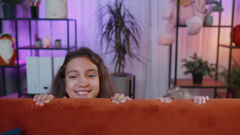 two young girls smiling and playing together on a couch