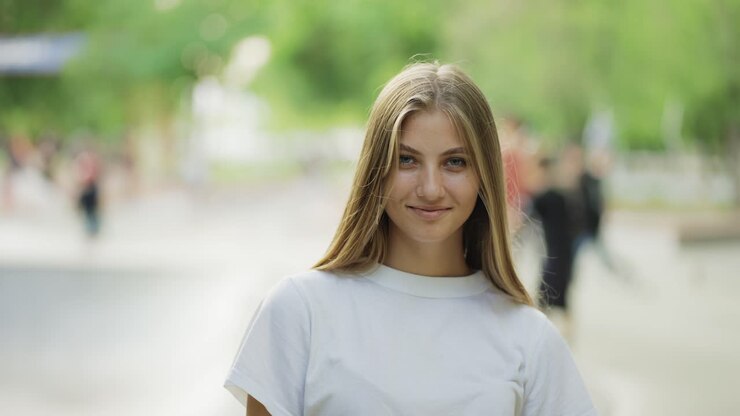 Beautiful young blonde posing against the backdrop of a crowded park. Walk in the park, picnic. Happiness