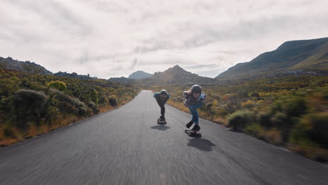 young woman longboarding overtaking in competitive race cruising on countryside road friends skating together riding skateboard wearing protective helmet