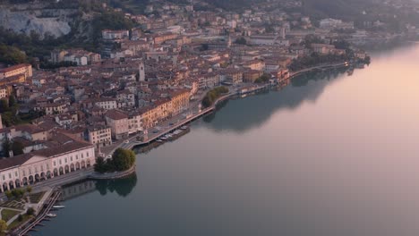 vista de drones del lago iseo al amanecer, a la izquierda la ciudad de lovere que corre a lo largo del lago, bergamo italia