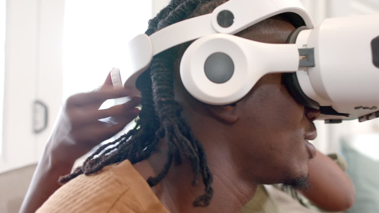 Adjusting VR headset, person experiencing virtual reality at home with partner