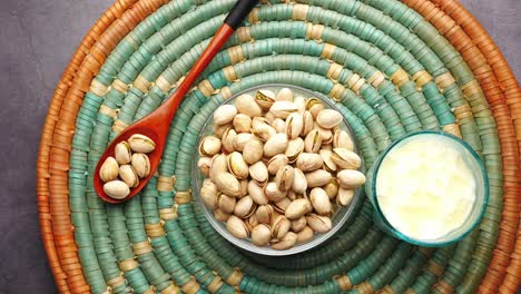 pistachios and yogurt on a woven placemat