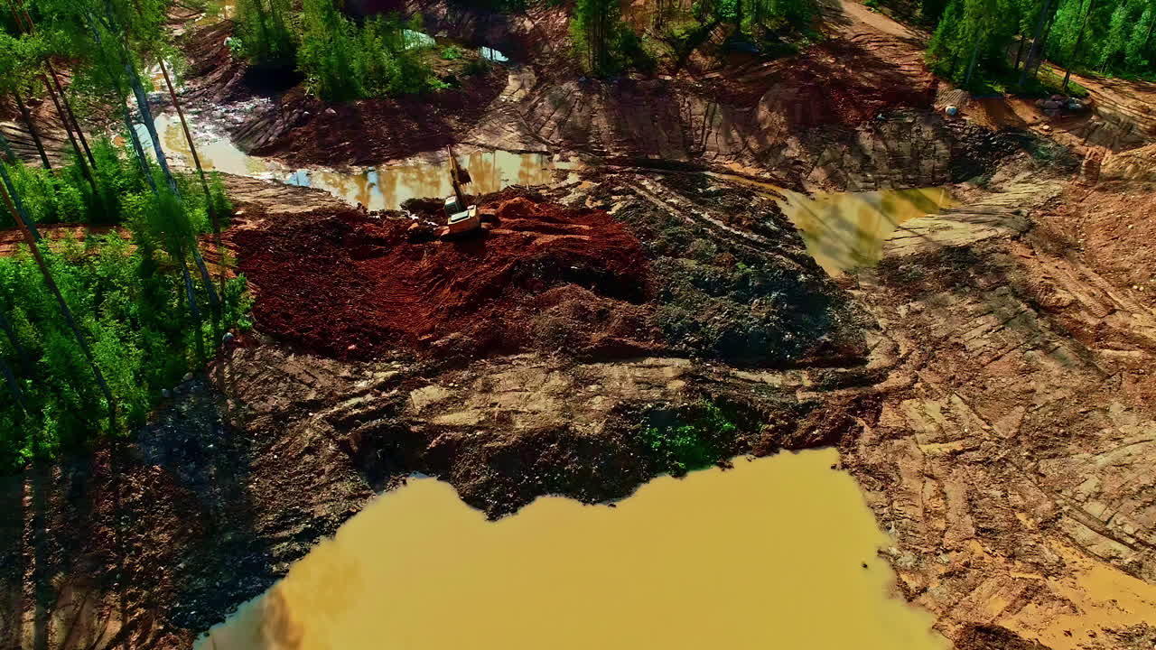 toma aérea de drones en movimiento hacia atrás de áreas deforestadas que afectan el flujo del río y jcb nivelando la tierra para fines de desarrollo durante el día