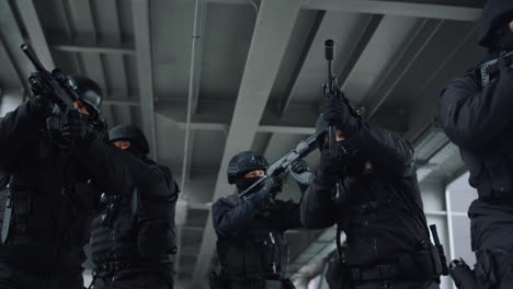 Equipo-De-Policía-De-Operaciones-Especiales-Protegiendo-El-Edificio-Urbano-Con-Rifles-De-Asalto.