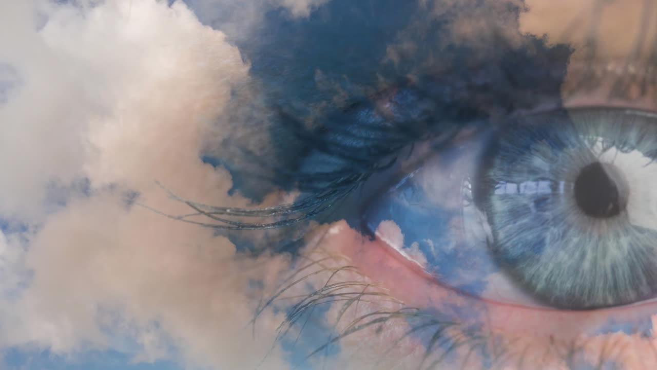primer plano del ojo azul femenino contra las nubes en el cielo azul