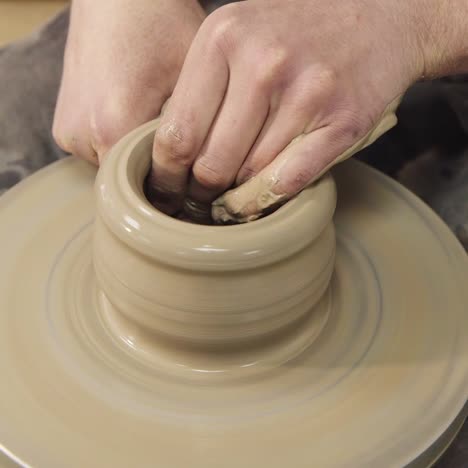 the hands of a potter make a jug on a potter's wheel 1