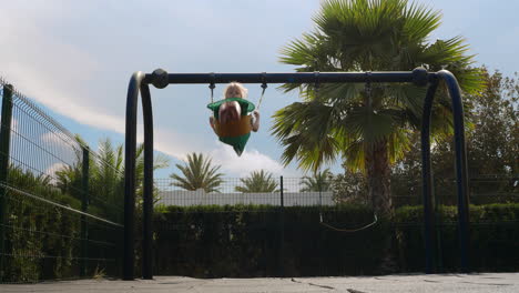 child swinging on playground swing set