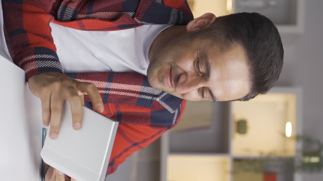 el video vertical del hombre mirando el álbum de familia es feliz.