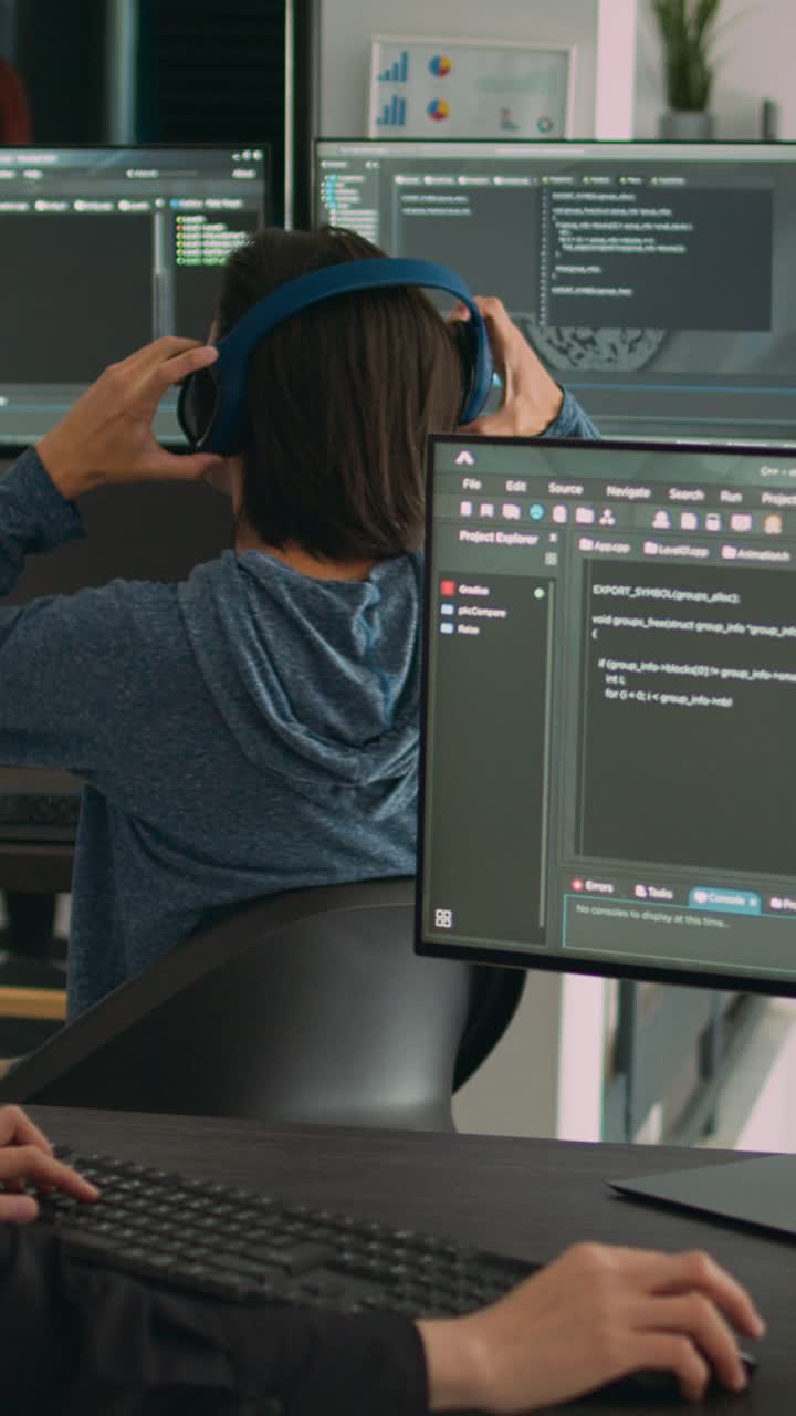Vídeo vertical: programadora escribiendo código fuente en el teclado del ordenador