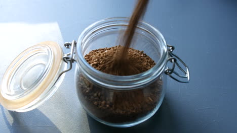 Pouring-coffee-granuals-into-a-jar