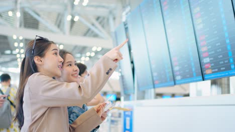 mujeres comprobando la información de vuelo en el aeropuerto