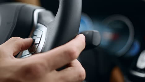 man pushing buttons on steering wheel