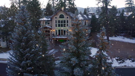 christmas decorated family home in snowy winter town, aerial pull away shot