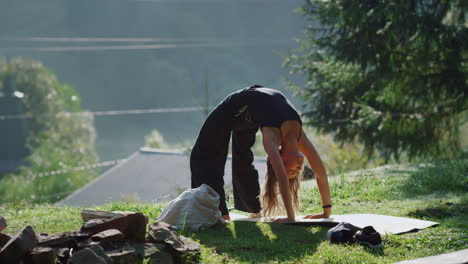 young woman doing bridge pose on hill