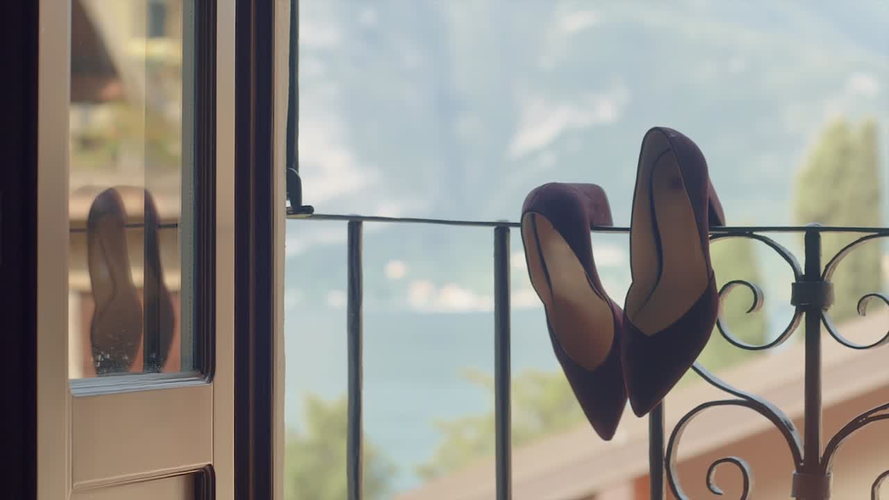 발코니 울타리에 걸려있는 여자 드레스 슈즈