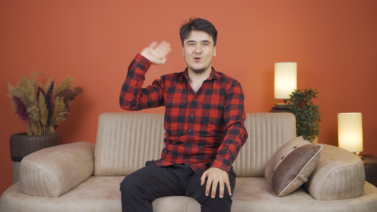 카메라를 향해 손을 흔들고 있는 남자