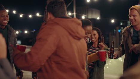 young-group-of-multiracial-friends-having-fun-dancing-playfully-together-enjoying-rooftop-party-at-night-laughing-celebrating-friendship