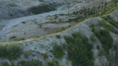 extreme athletes riding mountainbikes on gravel ridge at mount st helens foothills, aerial