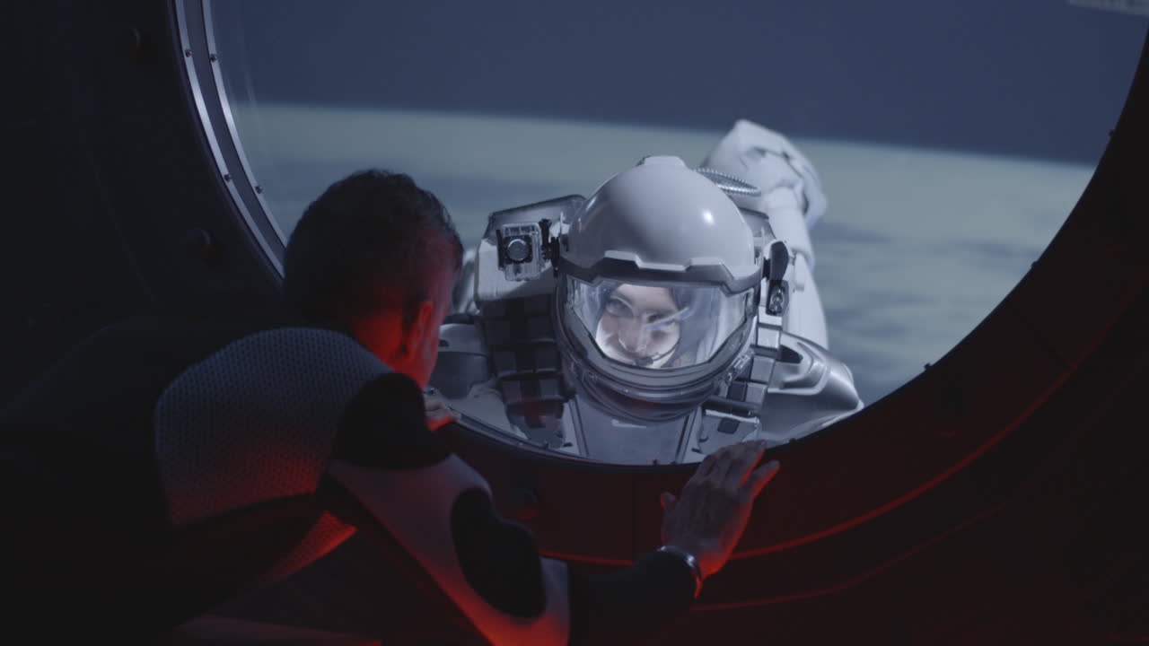 Astronaut Spacewalk Viewed Through a Spacecraft Window