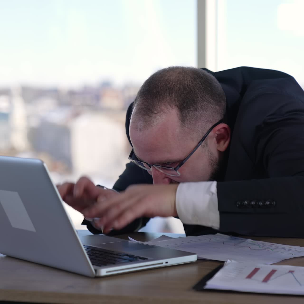 Man doing funny faces sitting in front of laptop. Mad businessman typing nervously with fingers on keyboard and looking to the sides. Entrepreneur with insane face in office
