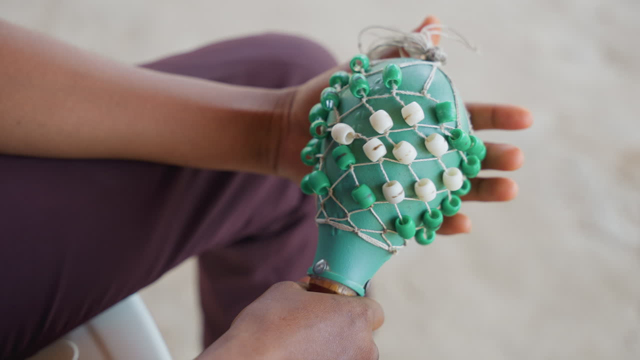 Sanftes Rasseln in friedlicher, sonniger Umgebung. Entspannendes Babyspielzeug im Sonnenlicht in ruhiger Atmosphäre. Ruhige Szene, die eine sanft schüttelnde Babyrassel unter hellem Sonnenlicht in friedlicher Atmosphäre zeigt.