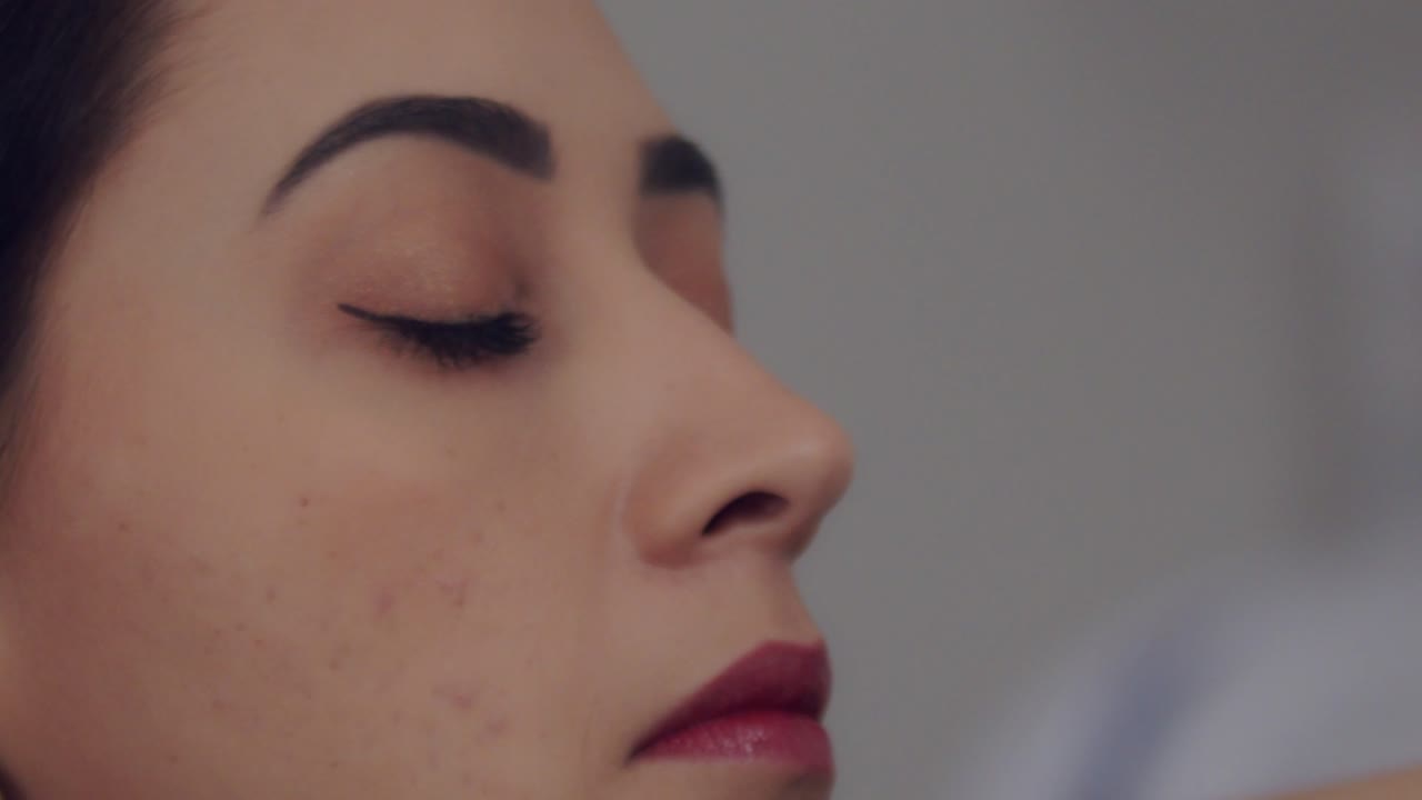 Giovane donna ispanica che si prepara per il lavoro e si pettina i capelli all'indietro