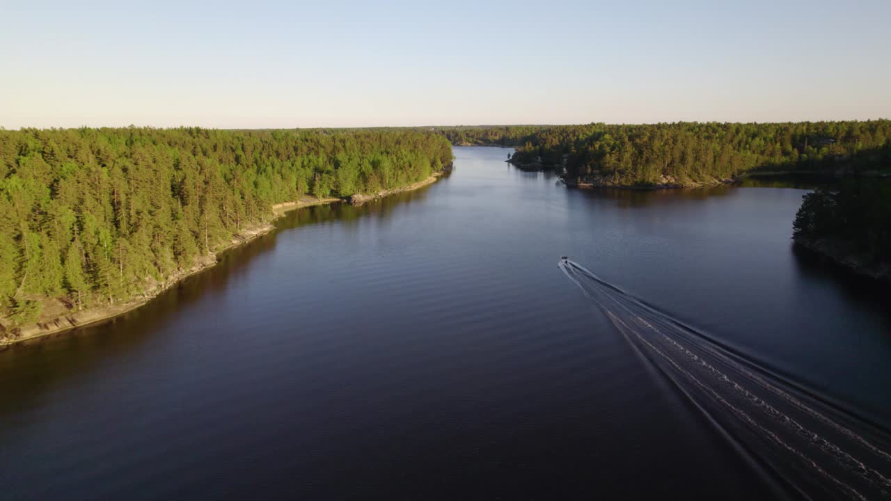 vista aérea siguiendo un barco, conduciendo en el archipiélago sueco, hora dorada, en suecia